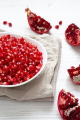 Red Pomegranate Seeds in a White Bowl , side view.
