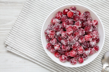 Red Sugared Cranberries in a Bowl, top view. Flat lay, overhead, from above. Copy space.