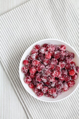 Red Sugared Cranberries in a Bowl, top view. Flat lay, overhead, from above. Space for text.