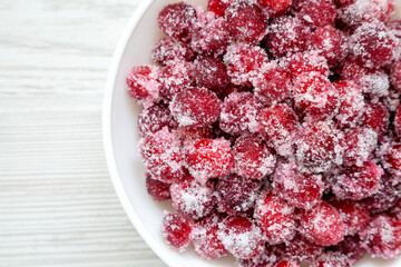 Red Sugared Cranberries in a Bowl, top view. Flat lay, overhead, from above. Copy space.