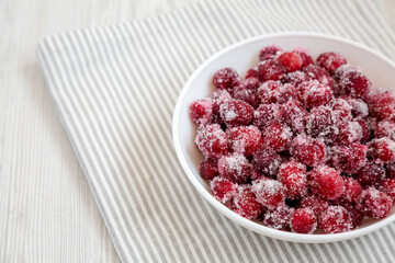 Red Sugared Cranberries in a Bowl, side view. Copy space.
