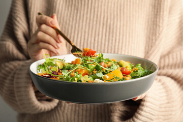 Woman eating delicious salad with lentils and vegetables, closeup