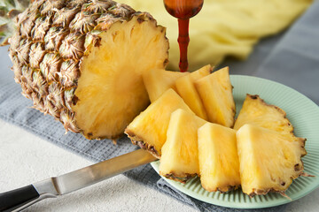 Ripe pineapple with sliced pieces on a plate.