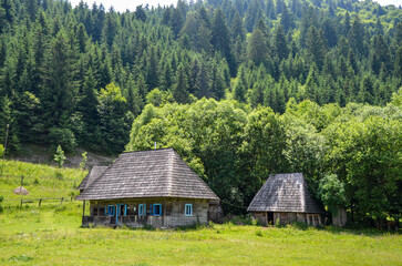 Obraz premium Rural landscape of ancient old wooden houses in the traditional style in the mountain village Kolochava, Transcarpathia, Ukraine