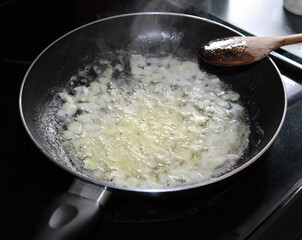 Chopped onions cooking in the frying pan.