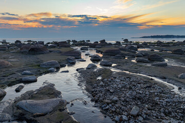 Rocky coast of Baltic sea at sunset. Low tide