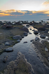 Rocky coast of Baltic sea at sunset. Low tide