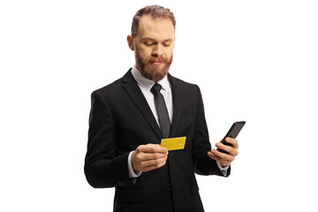 Businessman looking at a credit card and holding a mobile phone