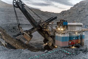 An electric excavator works in an open pit.