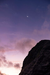 Moon and star over mountain peak