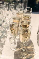 catering. beautiful glasses of champagne with bubbles on the table in the sun. serving. party. wedding