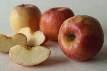 A crop of red fresh apples, randomly placed along with juicy slices
