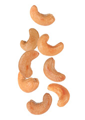 Tasty roasted cashew nuts falling on white background