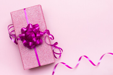 Valentine's day, mother's day or women's day concept. Glitter pink gift box and swirl ribbon on...