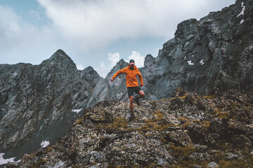 Man trail running alone hiking in mountains travel climbing adventure active extreme vacations...