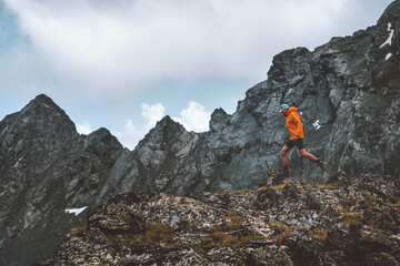 Active man trail running in rocky mountains extreme travel energy endurance concept hiking...