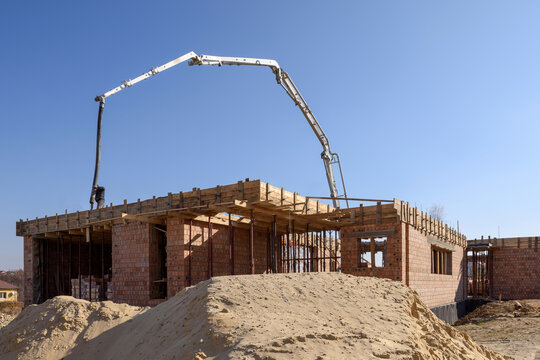 Truck mounted concrete pump at a construction site. Builder is pouring concrete into a wooden formwork. Private house construction.
Element of the unfolded hydraulic boom of the construction machine.