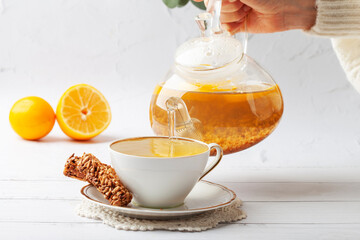 
Drink healthy buckwheat tea. The hand holds a glass teapot for brewing tea. Health care or herbal medicine concept.