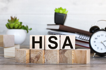Wooden cubes with words HSA Health Savings Account Business and HSA concept.