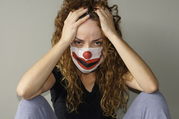 Woman with a clown-painted protective mask, already tired of this pandemic.