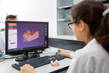 Person working on computer with dental software platform for make dental prosthesis
