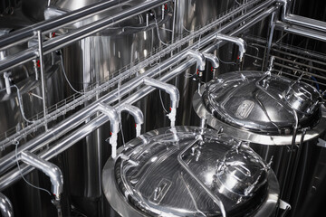 Modern Beer Factory. Steel tanks for beer fermentation and storage. Brewery. Modern beer plant with brewering kettles