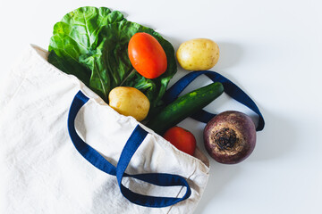 Eco bag with vegetables on white background. Flat lay, top view, copy space.