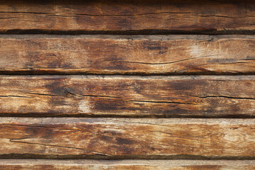 Wooden wall from log as background. Obsolete carpentry boards, panel. Surface of wooden texture for design and decoration. Dark brown horizontal wood plank grunge texture. Rustic backdrop. Copy space