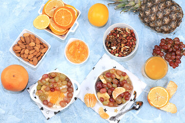 Fototapeta na wymiar Detox diet and weight loss concept, healthy breakfast with ingredients, Fruit drink and summer tropical fruits, juices, smoothies on blue table, top view, healthy and natural food, source of vitamin C