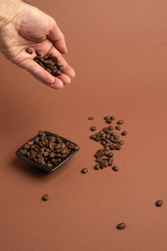 Mano muestra granos de caf&eacute; recipiente negro