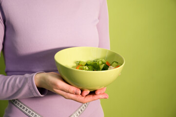 Closeup of a woman holiding bowl with vegan salad. Banner with place for text