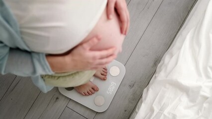 Young woman measuring her pregnant weight standing on scales. Preparation for childbirth, Girl big belly advanced healthy pregnancy.