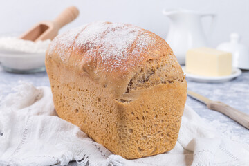 Loaf of homemade no knead sandwich bread with white cloth, horizontal