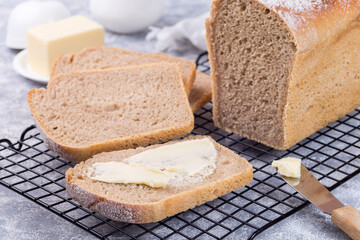 Homemade no knead sandwich bread with butter, on cooling rack, horizontal