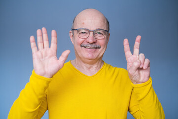 Naklejka premium Senior man raising hand, showing number seven with fingers, counting something