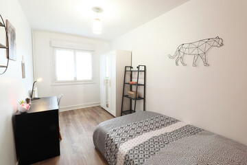 nice room with a black desk.a panther on the wall.A white wardrobe and a bed.  (France - 15.09.2021)