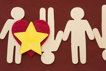 wooden figure silhouettes arranged with felt heart and painted star on fabric