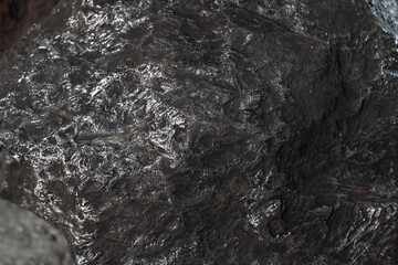 Obraz na płótnie Canvas Stone black textured background. A metallic glow on the stone