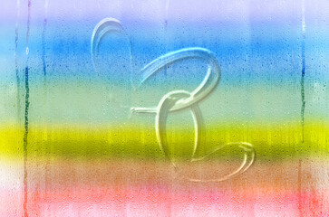 Two hearts on a background of glass with drops painted in the colors of the rainbow. Place for text
