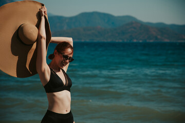 girl on the beach, big hat on the sea