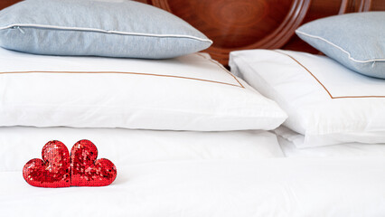 Blurred Romantic interior for Valentine's day with bed. Two red hearts on a white.