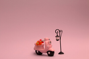 pink motorcycle with flower bouquet and retro street lamp  on a pink background. A romantic concept...