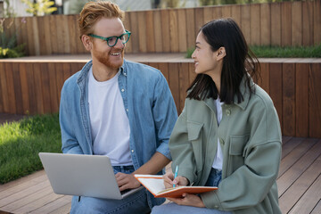 Smiling students studying, learning language, exam preparation sitting in university campus. Education concept. Group of successful business colleagues meeting, planning start up, working together 