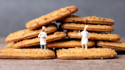 Square cookies and two miniature chef. Miniature people and business concept.
