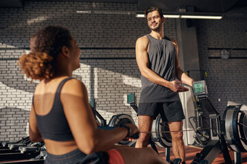 Naklejka premium Trainer showing black girl sport indicators in gym