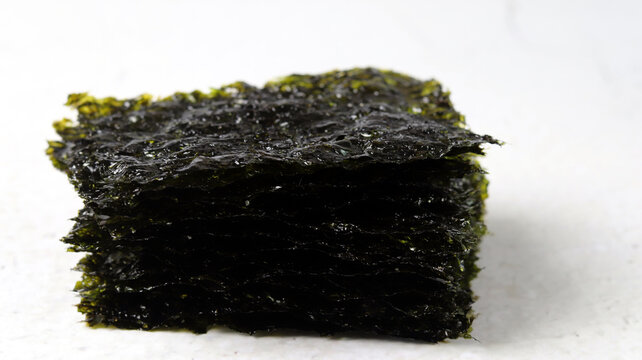 A close-up image of laver against a white background. Concept about healthy seaweed food ingredients.
