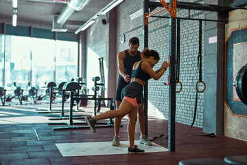 Obraz na płótnie Canvas Trainer teaching girl warming up in sport club