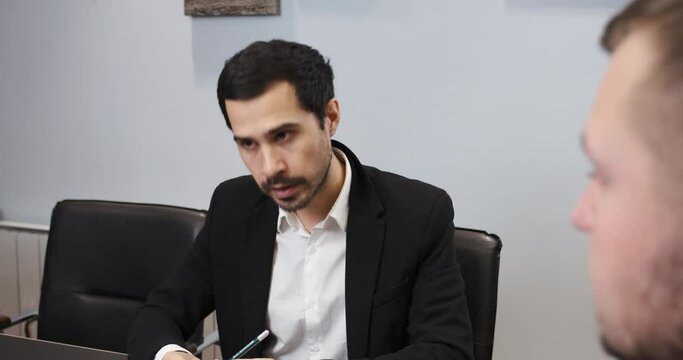 Employee talking to his boss in the office, worker feels guilt, he apologizes. Giving excuses after making a mistake, being guilty. Boss reprimands the subordinate