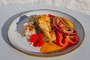 white salmon with gourmet sauce and rice with vegetables decorated with flowers