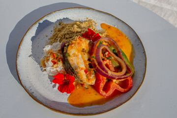 white salmon with gourmet sauce and rice with vegetables decorated with flowers